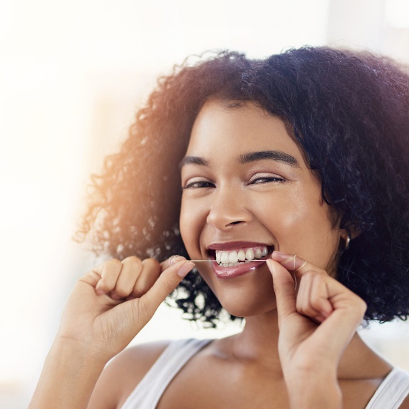 Girl flossing her teeth.